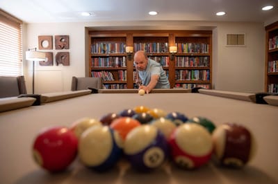 Resident playing billiards in a game room