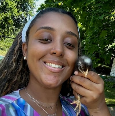 Staff member holding a chick outdoors