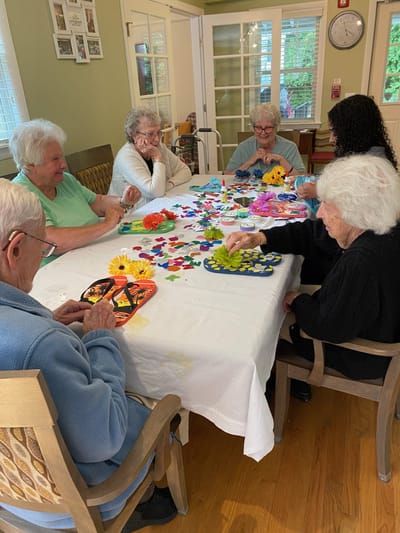 Residents engaged in a craft activity at a common area table
