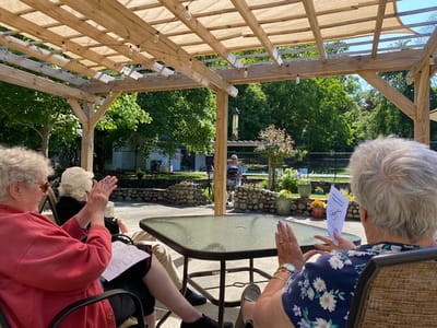 Residents enjoying an outdoor activity under a pergola