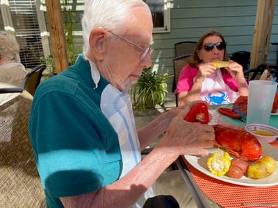 Resident enjoying a lobster meal outdoors