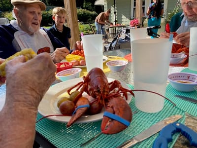 Residents enjoying a lobster feast in an outdoor setting