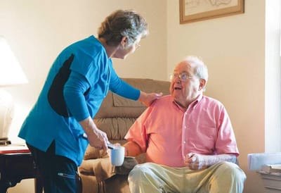 Staff member interacting with a resident in a cozy interior