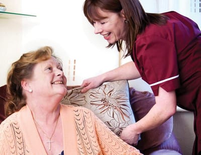 Caregiver assisting a resident in a living area