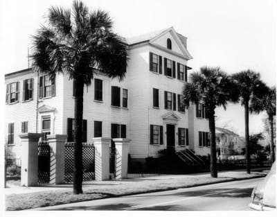 Exterior view of a historical building with palm trees