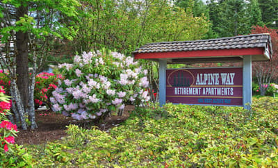 Exterior sign of Alpine Way Retirement Apartments with flowers