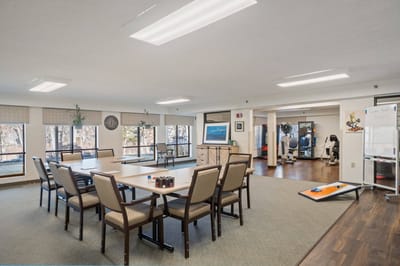 Bright dining area with tables and fitness room visible