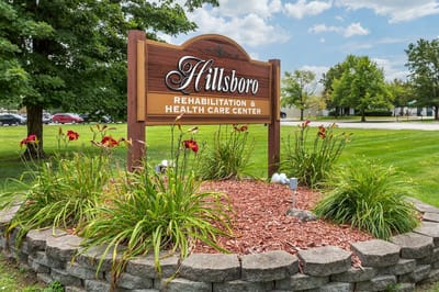 Sign for Hillsboro Rehabilitation & Health Care Center surrounded by flowers