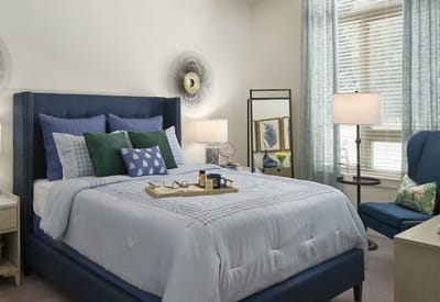 Cozy bedroom setup with a neatly made bed and seating area