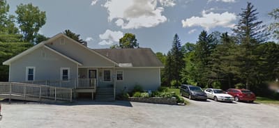 Front exterior of Our House Residential Care Homes with parking area