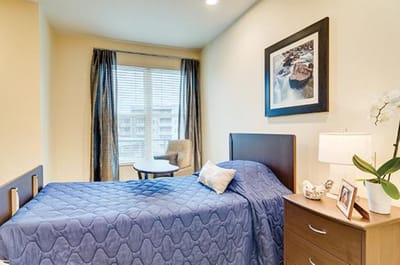 Cozy resident room with blue bedding and artwork