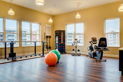Bright fitness room with exercise equipment and therapy balls