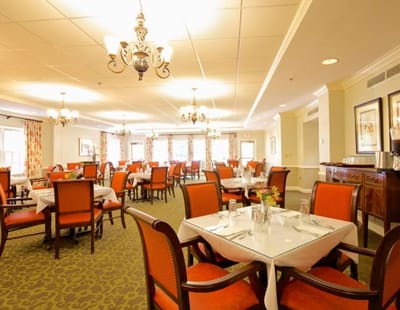 Dining room set up for a meal with tables and chairs