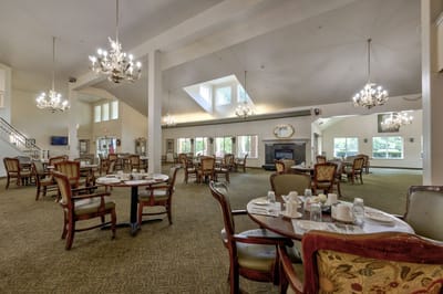 Bright dining area with set tables and chandeliers