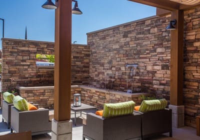 Outdoor seating area with stone wall and fountain