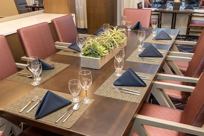 Dining table set for a meal with linens and glassware