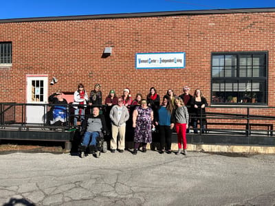 Group photo of residents and staff outside the facility