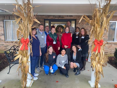 Group photo of staff in front of the facility entrance