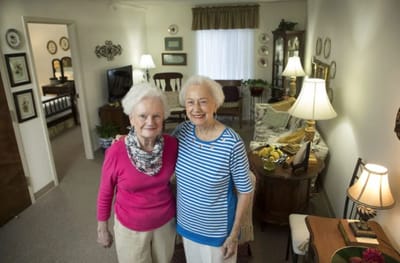 Two residents smiling in a cozy living space