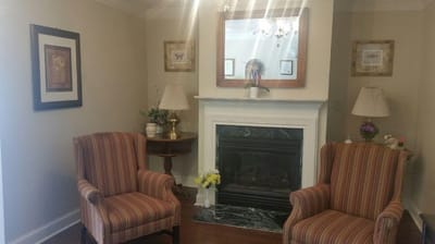 Cozy sitting area with striped armchairs and a fireplace