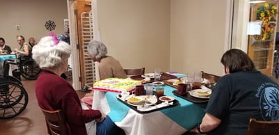 Residents enjoying a meal with cake in a dining area