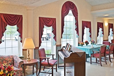 A bright common area with a piano and seating