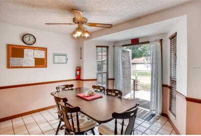 Dining area with a table and chairs, exit door visible