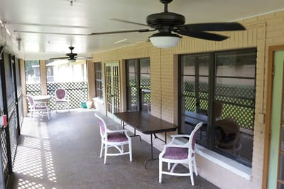 Covered outdoor seating area with chairs and a table