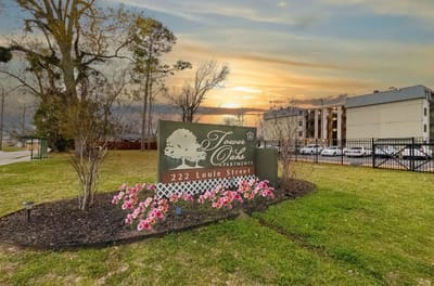 Exterior view of Tower Oaks Apartments with flowers.