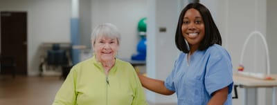 Resident and staff member smiling together