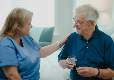 Caregiver interacting with a resident in a room.