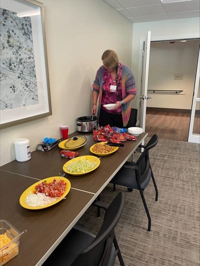 Staff member preparing food at a dining table