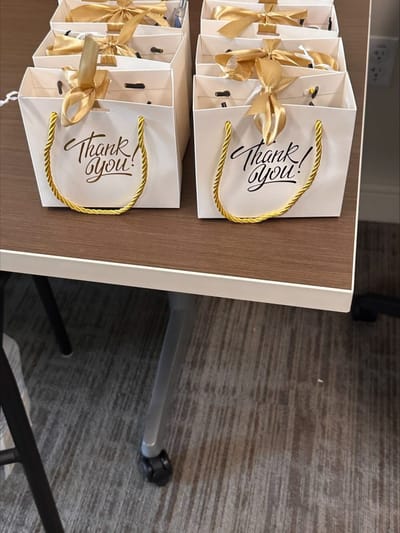 Gift bags on a table with a 'Thank you!' note.