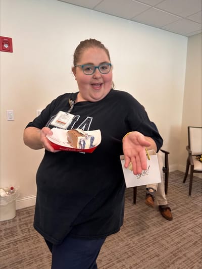 Staff member holding a dessert during an event.