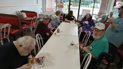 Residents enjoying meals in a dining area.