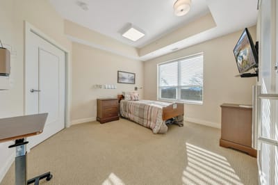 Cozy resident room with bed and TV.
