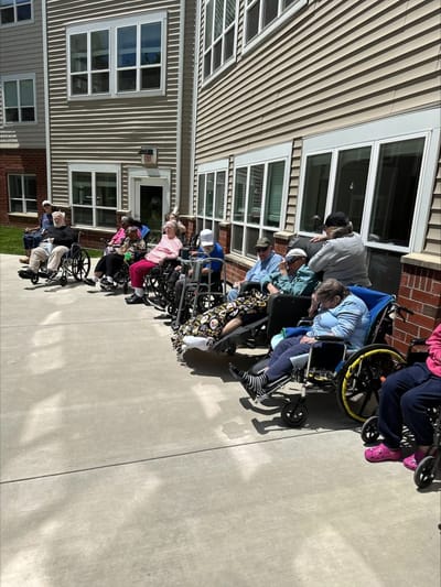 Residents enjoying time outdoors in wheelchairs.