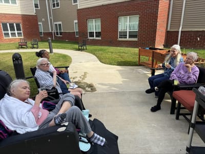 Residents enjoying drinks outside on a sunny day.