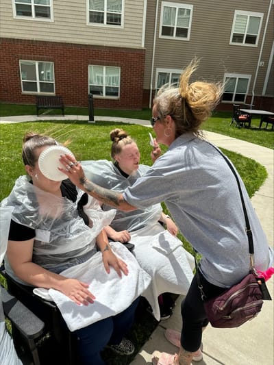 Residents participating in a playful activity outdoors.