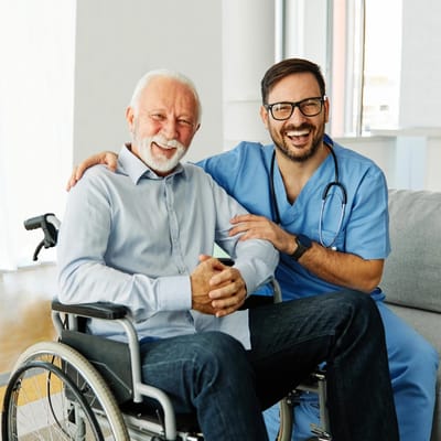 Senior resident with caregiver in wheelchair.