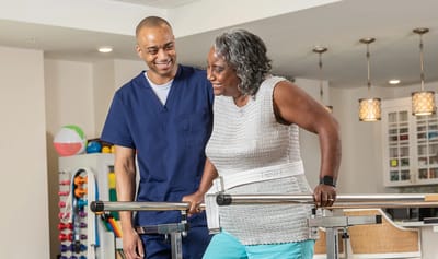 Therapist assisting a resident in rehabilitation.