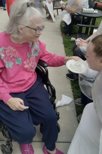 Resident engaging in an outdoor activity with staff