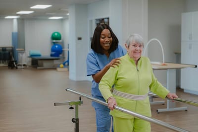 Therapist assisting an elderly woman with walking