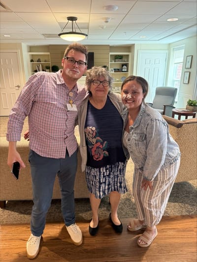 Three people smiling in a common area.
