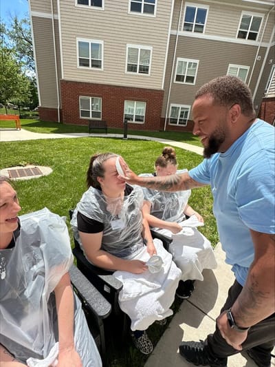 Residents enjoying an outdoor activity with staff.