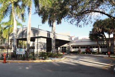Exterior view of Springtree Senior Living facility with palm trees
