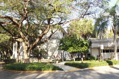 Exterior view of a senior living facility with trees and landscaping