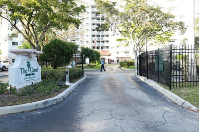 Entrance to The Court at Palm Aire with greenery