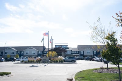 Exterior view of a senior living facility with flags