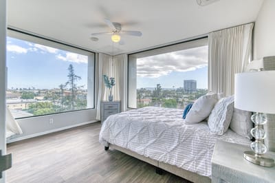 Bright bedroom with large windows and city view